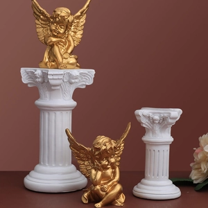 Golden angel statues on white Roman columns for wedding decor and photography props