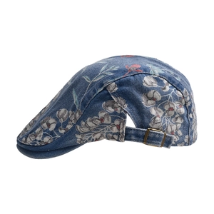 Detailed side view of a vintage floral denim newsboy cap with metal adjustment buckle
