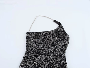 Detail of black sequined dress showing delicate silver chain straps and neck cut