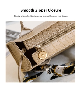 Détail du sac à main beige texture crocodile avec fermeture éclair et foulard en soie chic