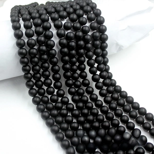 Detailed macro view of matte black stone round beads with a frosted texture for DIY jewelry