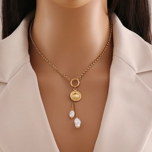 Elegant gold stainless steel necklace with shell pendant and pearl tassels on a model