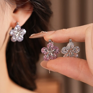 Gros plan de boucles d'oreilles fleurs en zircon rose et blanc étincelant