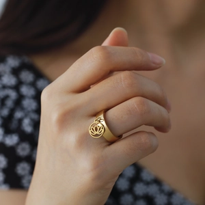 Gold stainless steel ring featuring a delicate lotus flower charm pendant for women