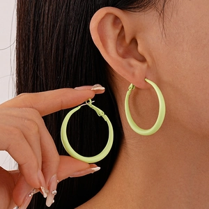 Detail of light green candy-colored hoop earrings showing the secure clasp and glossy finish