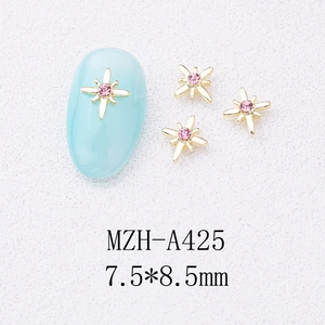Macro detail of star-shaped nail alloy charms with pink rhinestones for DIY nail art