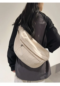Detailed texture of off-white corduroy waist bag worn on back with striped pattern