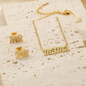 Detailaufnahme von goldenem MAMA Halsketten- und Ohrringset mit eingelegten Kristallen