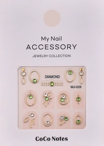 Detail of luxury green emerald and white zircon nail art charms with gold metal edges