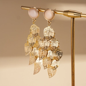 Detailed view of gold leaf fringe earrings with opal stones on a display stand