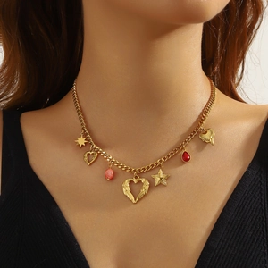 Gold plated stainless steel necklace with winged heart, star and red gemstone on model