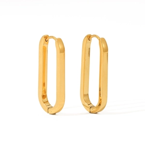 Macro shot of 18K gold plated stainless steel oval hoop earrings on white background