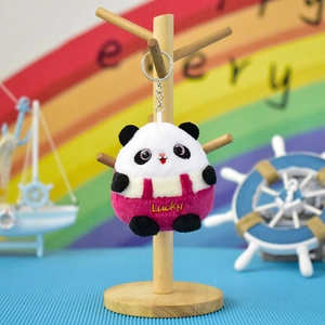 Close-up of a cute panda plush keychain with Lucky embroidery in a colorful setting