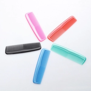Cinco mini peines de plástico de colores con dientes finos en un fondo blanco limpio