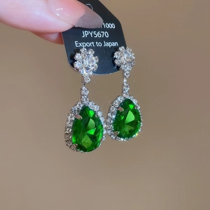 Macro di orecchini in argento con gemme verdi e piccoli diamanti bianchi incastonati