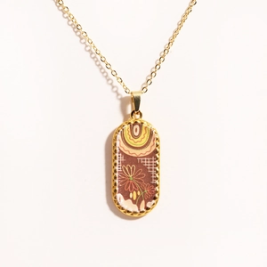 Close-up of 14k gold-filled tarot card pendant necklace with wave and plant patterns