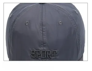 Detail of grey sport cap showing embroidered logo and reinforced stitching on top