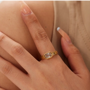 Macro detail of 18k gold plated ring featuring a square zircon and twisted band design