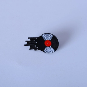 Detailed close-up of a melting vinyl record enamel pin with vibrant red and black colors