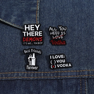 Detail showing creative black enamel badges with humor quotes on blue denim jacket