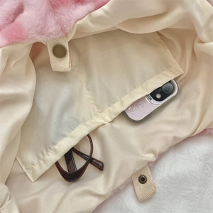 Detail of pink plush bag interior with cream fabric lining and inner storage pocket