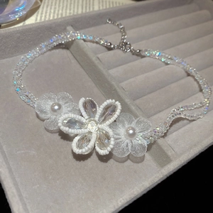 Detail of beaded flower necklace with crystal beads and pearls on velvet tray