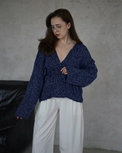 Dettaglio del cardigan in maglia grossa blu navy con scollo a V e trama spessa