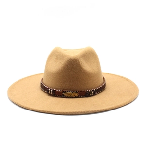 Close-up of camel wool fedora hat featuring a brown leather band and golden feather pin