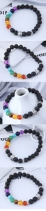 Macro detail of skull charm on lava stone chakra bead bracelet with colorful gemstones