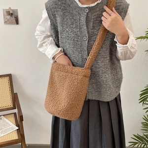Brown plush bucket bag shown with a model in a cozy home setting for winter style