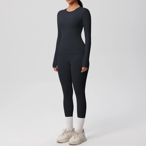 Détail de l'ensemble de yoga noir élastique avec manches à passe-pouce et legging haut
