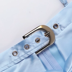 Détail de la robe en satin bleu clair avec boucle métallique, œillets et zip invisible