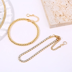 Two-piece gold-tone bracelet set with snake chain and rhinestones on white background