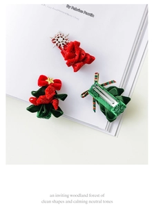 Detailed view of handmade Christmas tree hair clips with velvet ribbons and metal ducks