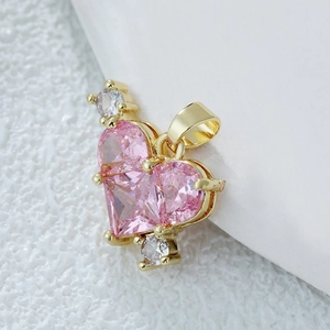 Collier cœur doré avec grand zircon rose et cristaux brillants sur surface texturée