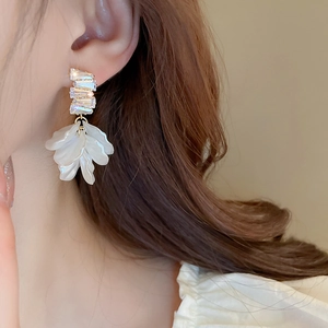 Detail of model wearing shell flower tassel earrings with sparkling zircon accents