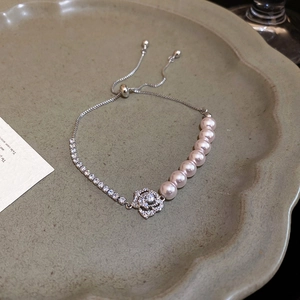Macro detail of adjustable floral pearl bracelet with pink zircon in silver finish