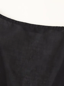 Close-up of black sleeveless shirt detailing delicate lace embroidery and woven fabric texture