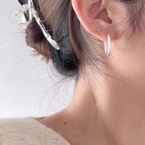 Minimalist S925 sterling silver oval hoop earrings worn by a model in a side view