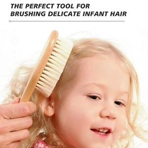 Macro shot of a soft wool baby hairbrush gently grooming an infant's delicate blonde hair