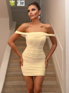 Close-up of light yellow off-shoulder mini dress with ruched mesh fabric texture
