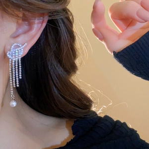 Silver drop earrings with sparkling zircon tassels and white pearls worn by a model