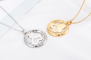 Detailed view of gold and silver necklaces with hollow butterfly pendants on textured white background