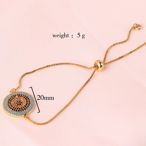 Detail of gold adjustable box chain bracelet with evil eye pendant and size labels