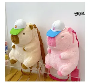 Detail of Capybara plush backpacks in cream and pink featuring cute caps and soft texture