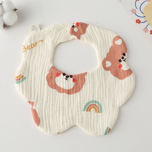Close-up of soft cotton gauze baby bib with cute brown bear and rainbow patterns
