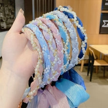 Detailed close-up of woven pastel headbands with pearls and braided chiffon fabric texture