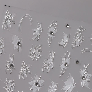 3D-Nagelaufkleber mit weißen geprägten Blumen, Schmetterlingsmustern und kleinen Strasssteinen