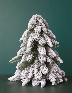 Close-up of artificial mini Christmas pine tree with dense white snow flocking detail