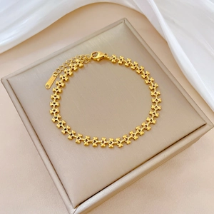 Gros plan du bracelet chaîne de cœur en acier titane doré avec fermoir mousqueton